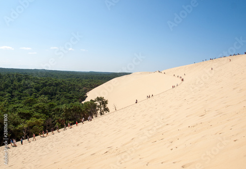 Fototapeta Naklejka Na Ścianę i Meble -   People walking on the top of the Dune of Pilat, the tallest sand dune in Europe. La Teste-de-Buch, Arcachon Bay, Aquitaine, France