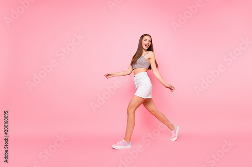 Full body photo of cute lady walking looking wearing white shirts tank-top isolated over pink background