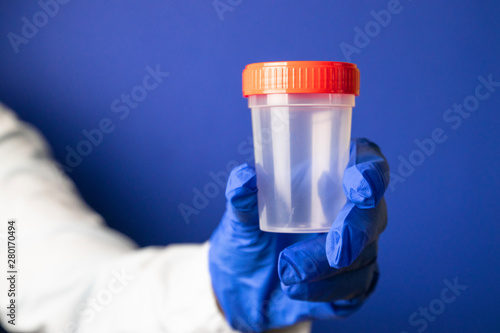Medical specimen collection bottle in gloved hand