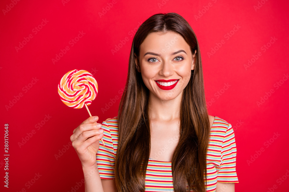 Closeup photo portrait of pretty nice good glad positive charming gorgeous lady holding big candy on stick in hand isolated vivid background