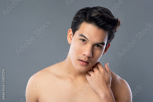 Portrait of shirtless young asian handsome man touching face photo
