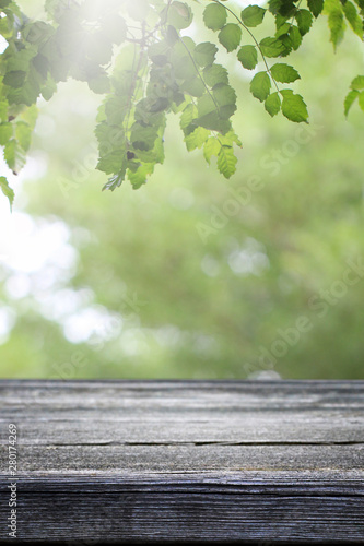 Wooden table and blurred green leaf nature in garden background. 