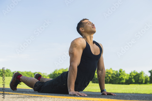 Athletic man practicing yoga outdoor