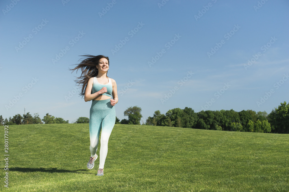 Athletic woman running outdoor in a park