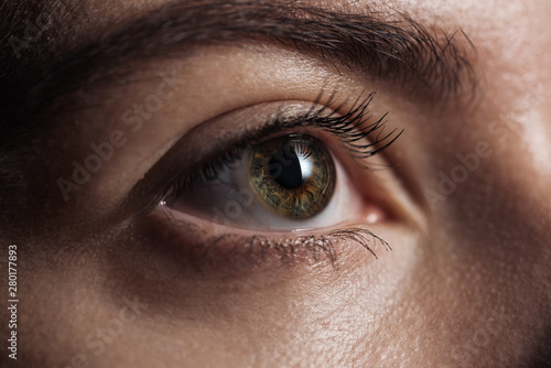 close up view of young woman green eye looking away