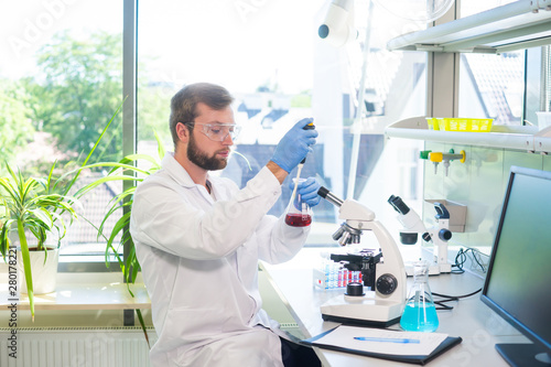 Scientist working in lab. Doctor making microbiology research. Laboratory tools  microscope  test tubes  equipment. Biotechnology  chemistry  bacteriology  virology  dna and health care.