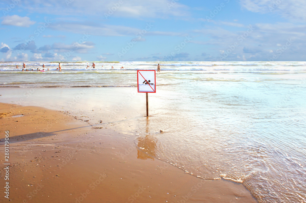 sign on the beach: swimming is prohibited. the beach is closed. crossed out man. Coast at the resort.