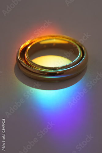 Two wedding rings with rainbow light.