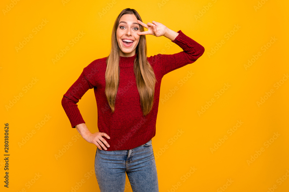 Photo of pretty lady showing v-sign near eye wear pullover isolated yellow background Photo of pretty lady showing v-sign near eye wear pullover isolated yellow background