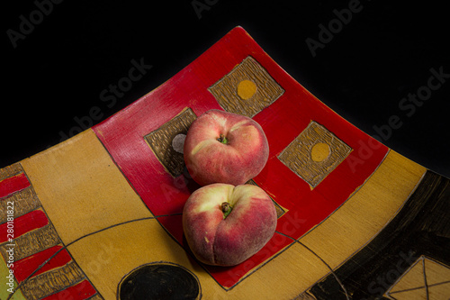 still life: food, ethnic tray in colored wood and inlaid with peaches photo