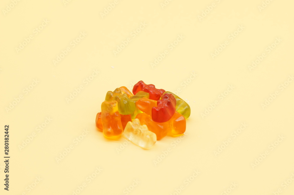 Sweet marmalade gummy bears on orange background