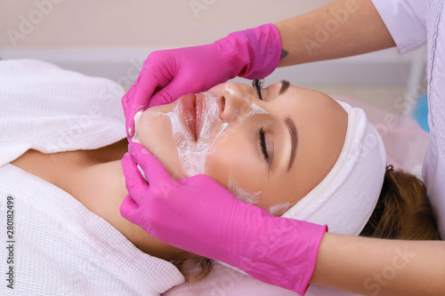 Spa Woman applying Facial cleansing Mask.