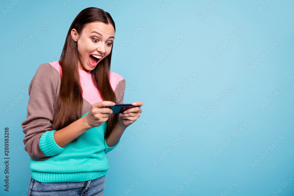 Photo of positive screaming playful lady using telephone for enjoying new digital game isolated vivid background Photo of positive screaming playful lady using telephone for enjoying new digital game isolated vivid background