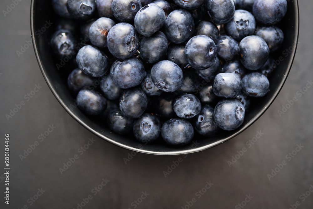 Top view of freshly picked blueberries in black bowl on dark background Top view of freshly picked blueberries in black bowl on dark background