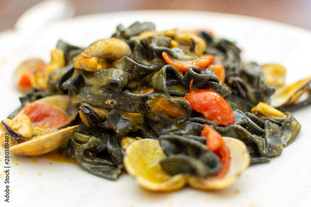 Seafood pasta dish, Italian black fettuccini with vongole clams and mussels Seafood pasta dish, Italian black fettuccini with vongole clams and mussels