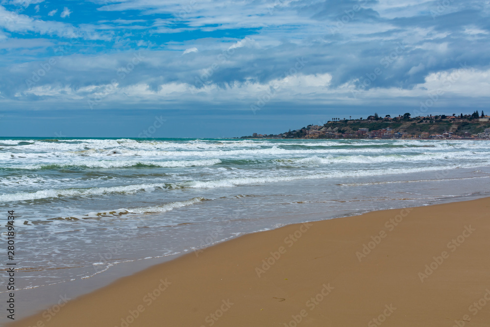 Scenic gray-blue clouds during sunrise over coastline with sandy beach and clear sea water in Agrigento, Sicily, Italy, summer vacation destination Scenic gray-blue clouds during sunrise over coastline with sandy beach and clear sea water in Agrigento, Sicily, Italy, summer vacation destination
