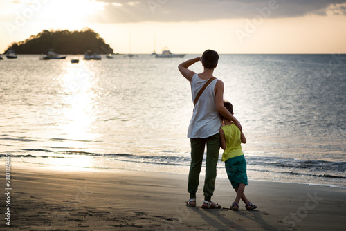 Mother and son looking the ocean from a beach at sunset. Concept of love and vacation. Playa del Coco, Costa Rica.