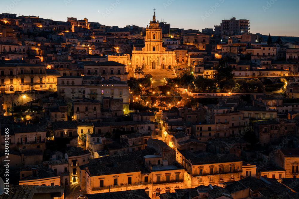 Panorama of the old baroque Modica city at night with street lights and illumination in Sicily, south Italy