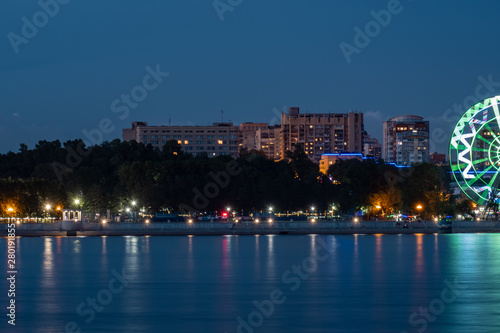 Night View of the city of Khabarovsk from the Amur river. Blue night sky. The night city is brightly lit with lanterns. © rdv27