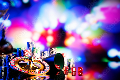 Casino concept. High contrast image of casino roulette, poker chips, dice. Bokeh background. 