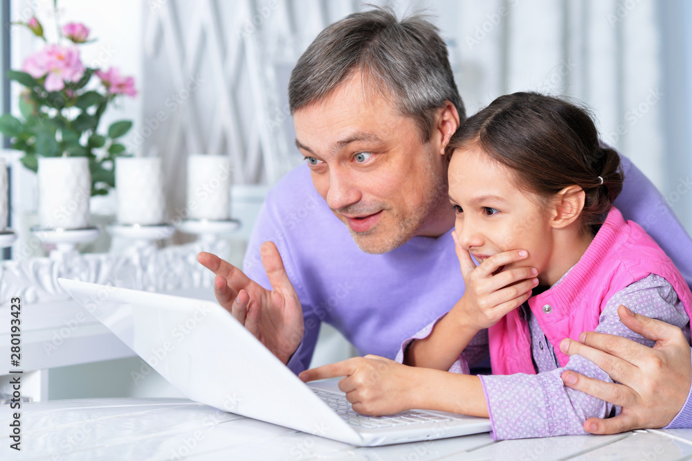 Portrait of father with little daughter using laptop Portrait of father with little daughter using laptop