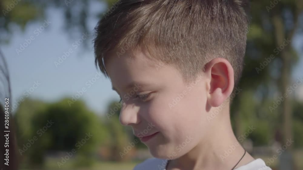 Portrait of a cute smiling boy outdoors. Adorable child spend time in the summer park. Portrait of a cute smiling boy outdoors. Adorable child spend time in the summer park.