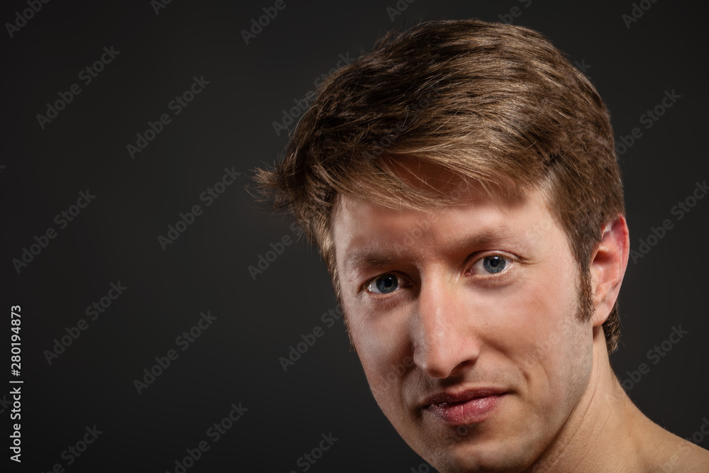 Fototapeta premium Young man's portrait. Close-up face against gray background