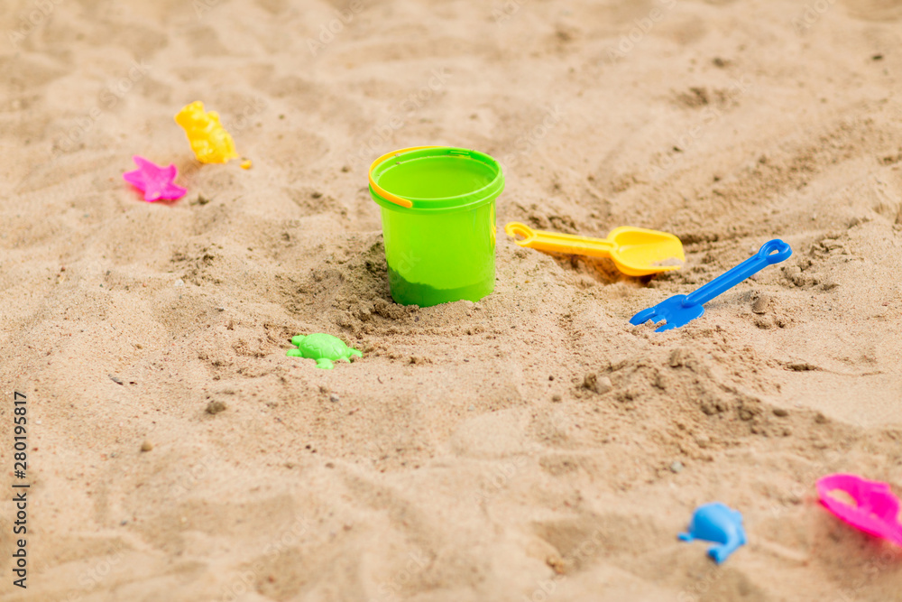 childhood and summer concept - bucket and sand toys on beach or in sandbox childhood and summer concept - bucket and sand toys on beach or in sandbox