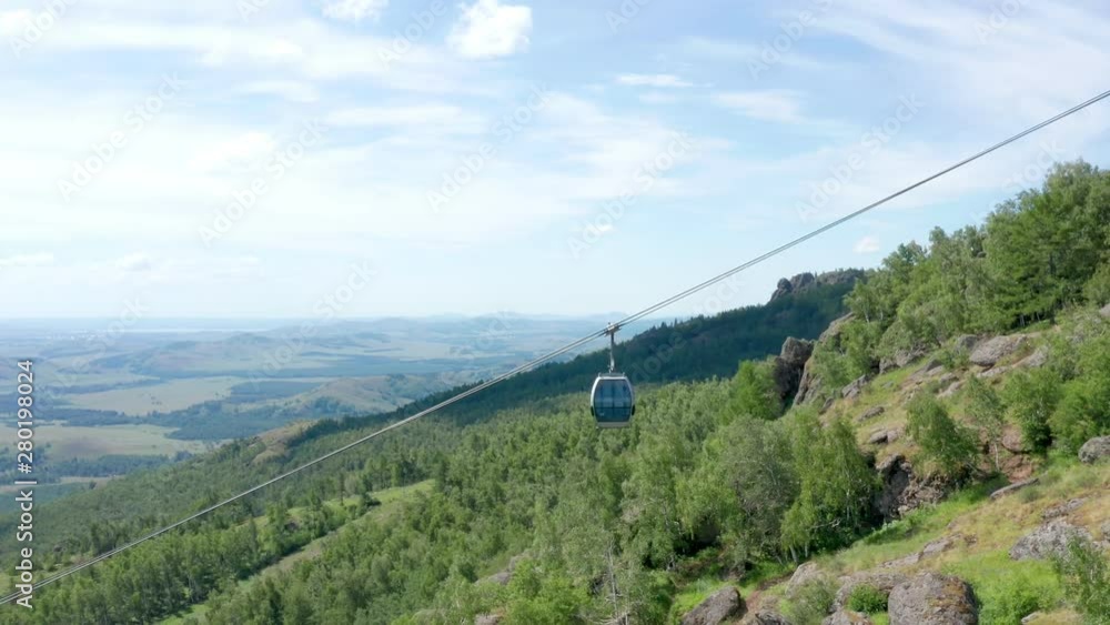 The follow shot the cable car. Beautiful landscape from the mountains to the valley. A shot of an empty cabin of a working ropeway. The follow shot the cable car. Beautiful landscape from the mountains to the valley. A shot of an empty cabin of a working ropeway.