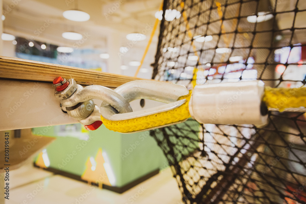 fastening a yellow nylon rope to a metal structure close-up. equipment in the obstacle course