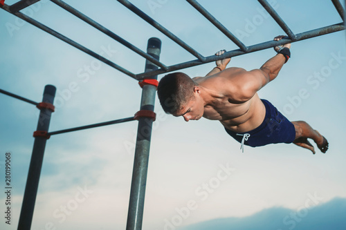 Obraz na plátně fitness, sport, training, calisthenics and lifestyle concept - young boy doing a black lever exercise on the street