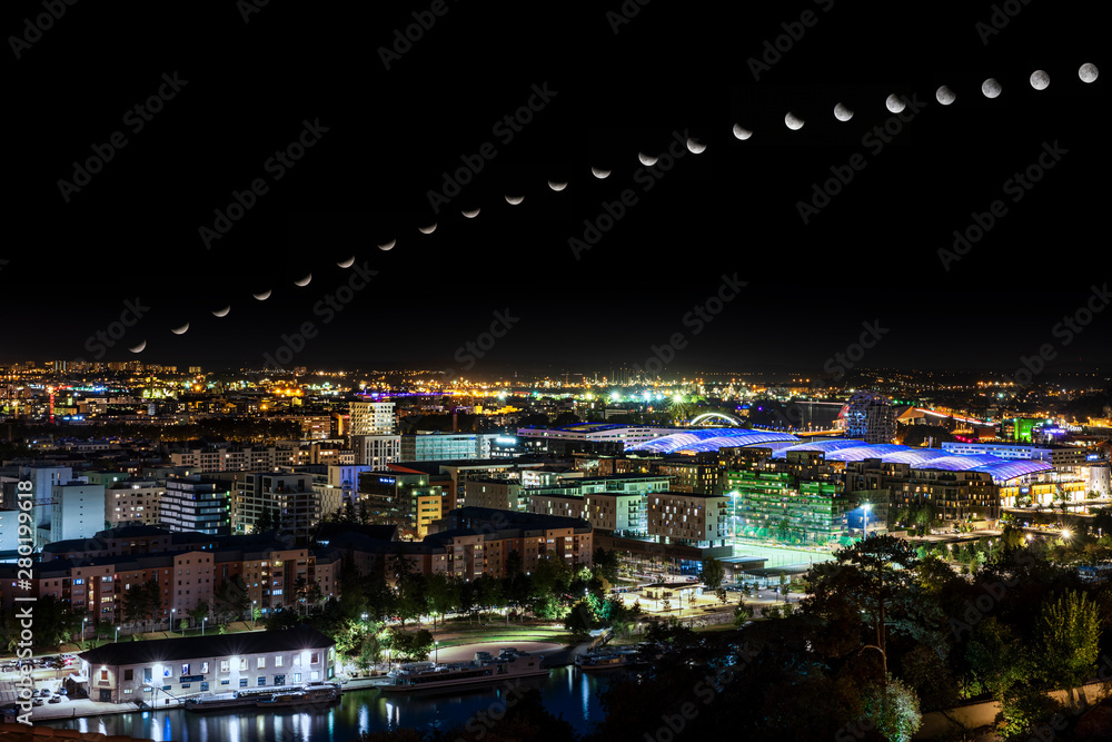 Fototapeta premium moon eclipse trajectory over the city at night