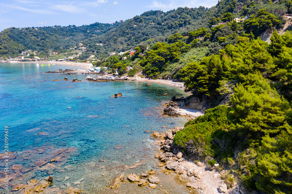 Aerial view of beautiful green and rocky island in the blue ocean.