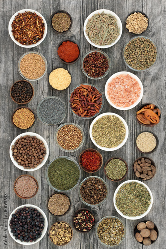 Dried herbs and spices on rustic wood background.