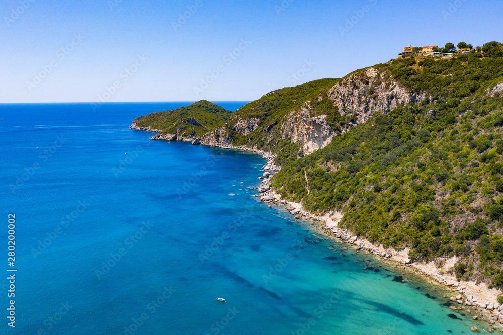 Aerial view of beautiful green and rocky island in the blue ocean.