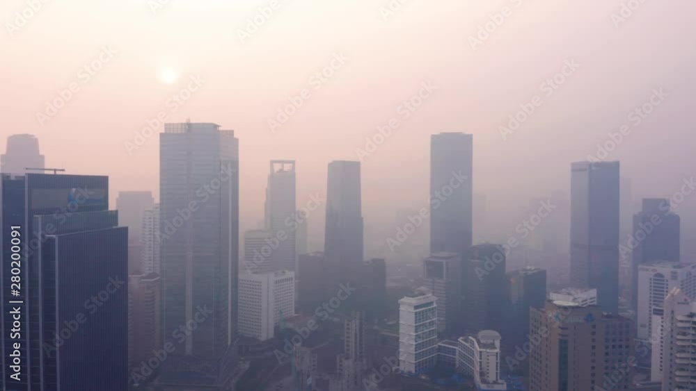 JAKARTA, Indonesia - July 17, 2019: Aerial view of air pollution haze and silhouette of skyscrapers in business center. Shot in 4k resolution from a drone flying forwards JAKARTA, Indonesia - July 17, 2019: Aerial view of air pollution haze and silhouette of skyscrapers in business center. Shot in 4k resolution from a drone flying forwards