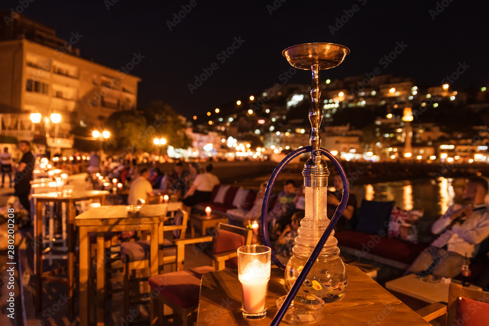 Φωτογραφία shisha on the table in restaurant, in the background city Ulcinj in Montenegro at night