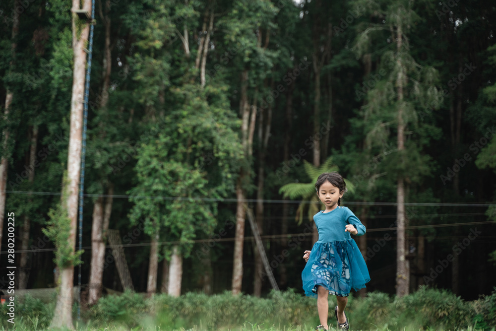 little girl alone running while enjoying playing in the park little girl alone running while enjoying playing in the park