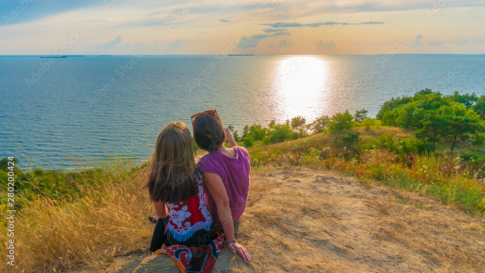 girls on a hill overlooking the sea