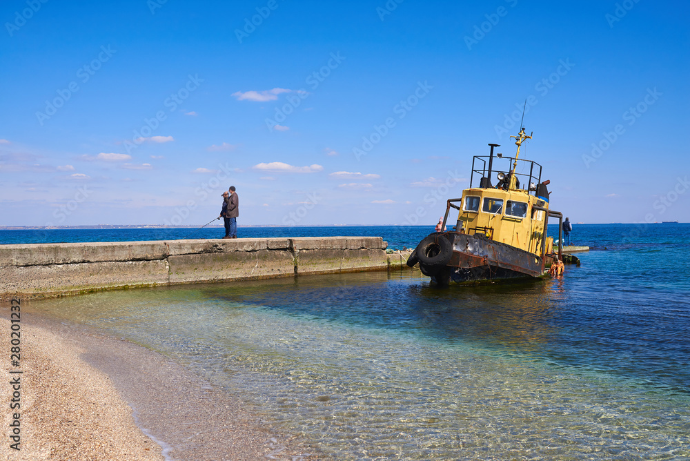 Fototapeta premium Fisherman and old ship on the Black Sea