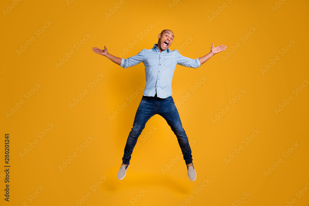 Full length photo of charming boy raise hands air fly shout enjoy isolated over yellow background