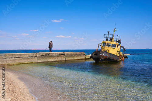 Fisherman and old ship on the Black Sea