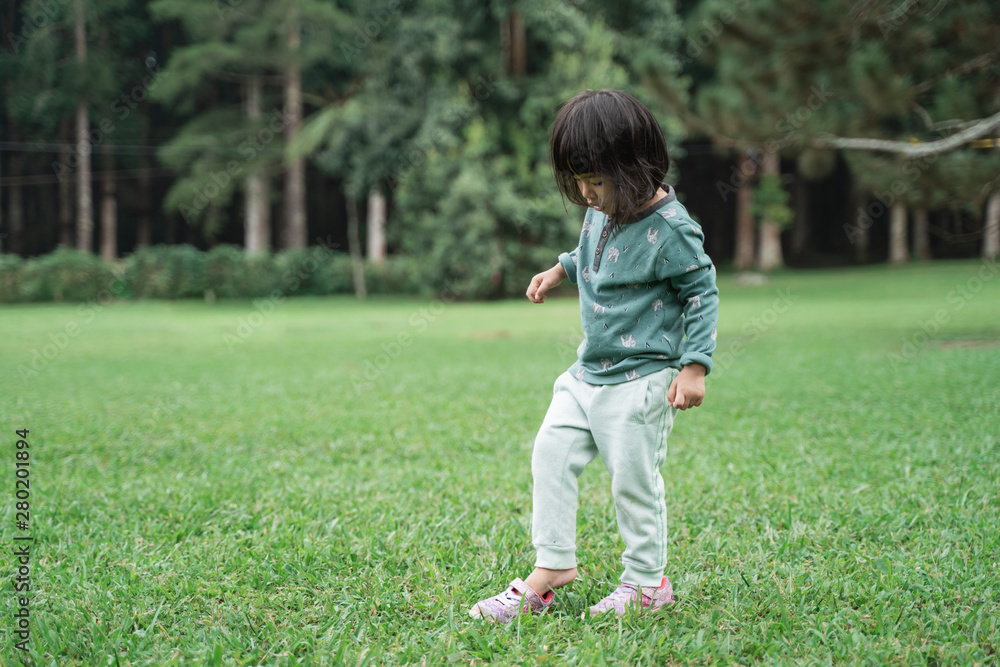 little daughter having fun alone while enjoying playing in the park little daughter having fun alone while enjoying playing in the park