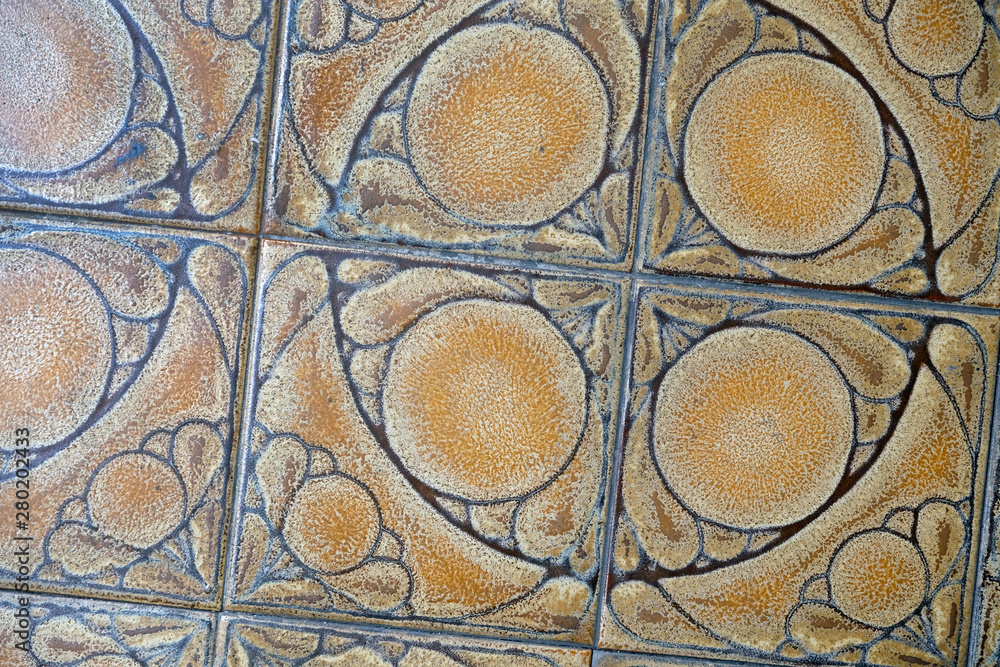 Fragment of a floor from a ceramic tile. Brown ceramic tiles with a pattern.