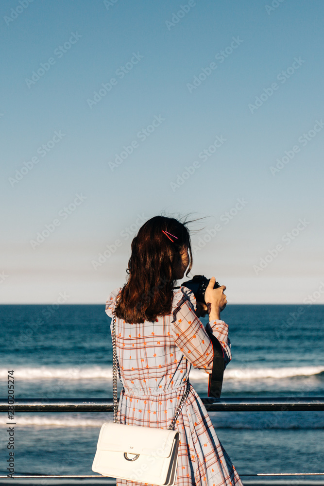 young woman taking picture on the beach