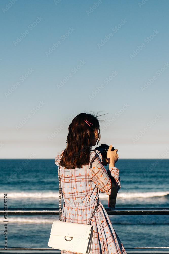 young woman taking picture on the beach young woman taking picture on the beach