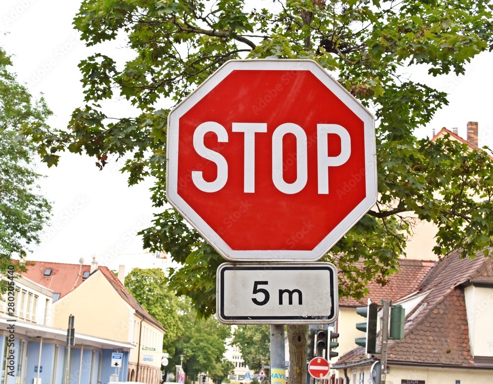 Traffic sign with a big red stop inside of an octagon.