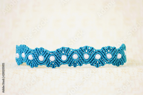Fototapeta Naklejka Na Ścianę i Meble -  turquoise bracelete with white beads for the hand from waxed thread in the technique of macrame. Handmade.