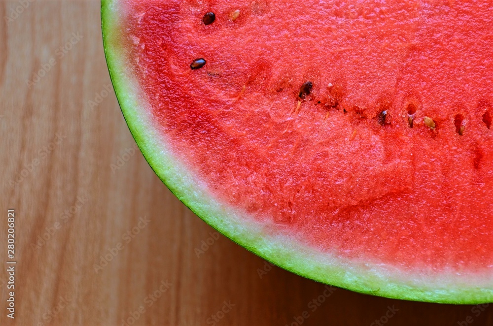 part of cut watermelon with seeds on the background of the wooden surface part of cut watermelon with seeds on the background of the wooden surface