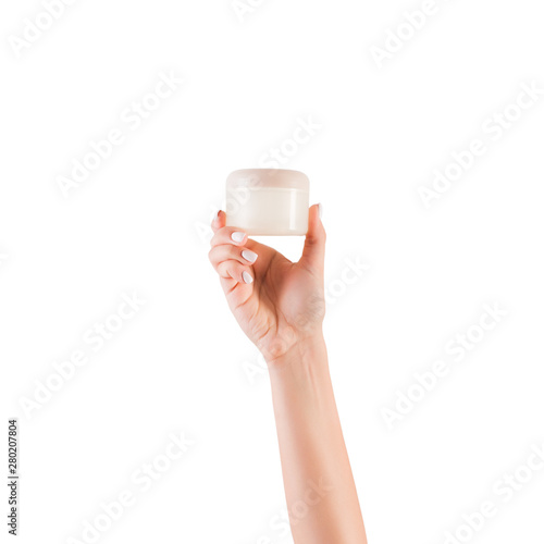 Female hand holding cream bottle of lotion isolated. Girl give jar cosmetic products on white background